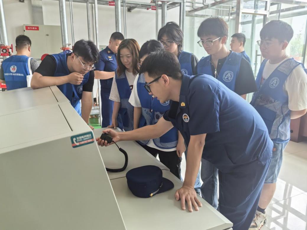 图片来源：天津商业大学    实践团向消防员学习消防设备使用